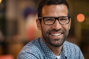A portrait of a smiling man looking closely at the camera